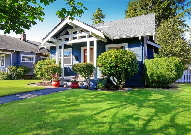 The curb appeal of a rental property is pictured, with a well maintained lawn and freshly painted exterior.